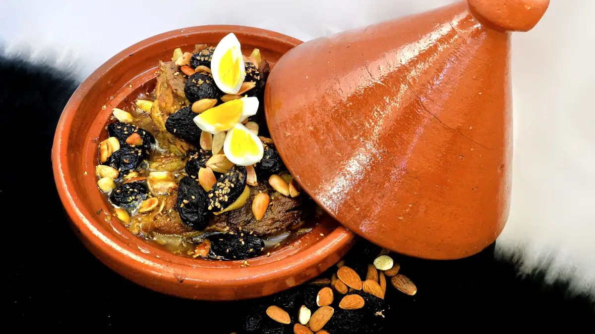 Tajine marroquí y pastela servidos en mesa tradicional