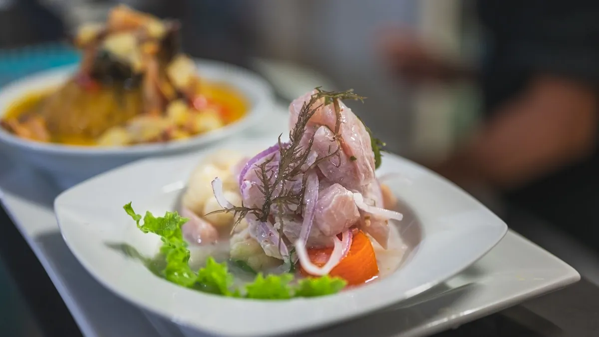 Plato de ceviche peruano con pescado blanco, cebolla roja, choclo y camote