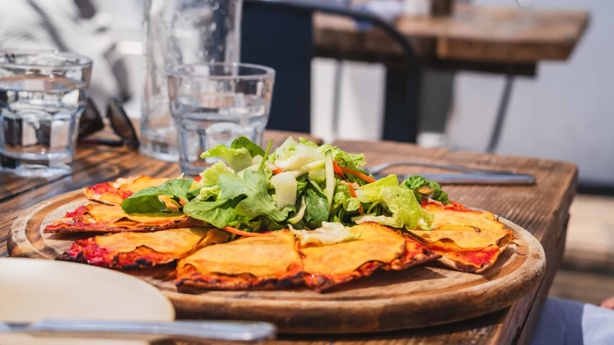 Comida niçoise servida en una tabla de madera en una terraza de Niza