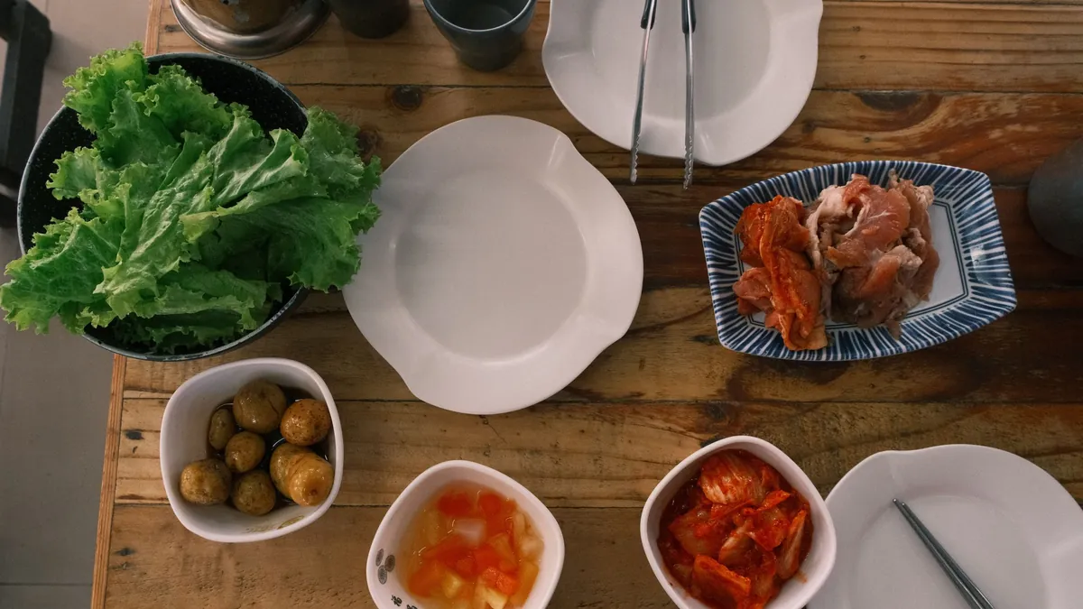 Mesa de barbacoa coreana con carne a la parrilla y platillos de banchan